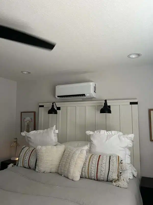 Ductless mini-split installation above bed.